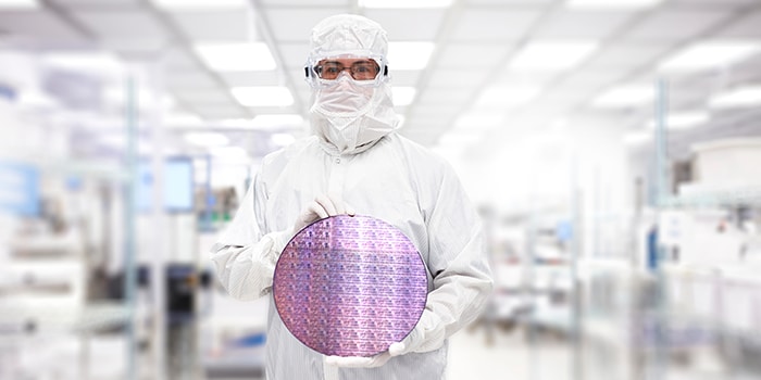 Lab associate holding semiconductor wafer chip